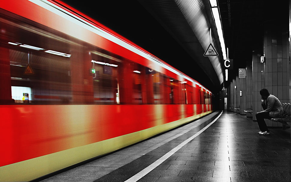 person sitting on bench waiting for train HD wallpaper